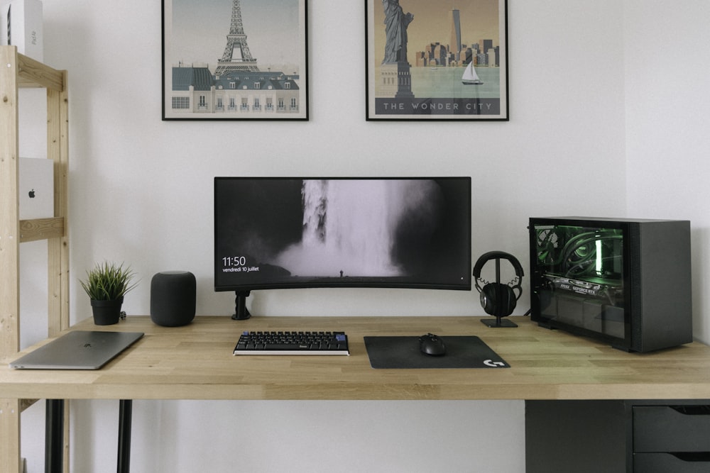 black flat screen computer monitor on brown wooden desk