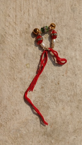 Close-up of a red thread and protective beads used in nazar protection rituals.