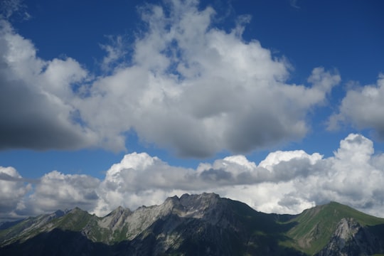green and brown mountains under white clouds and blue sky during daytime in Manigod France