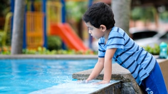 boy in blue and white striped shirt sitting on concrete bench
