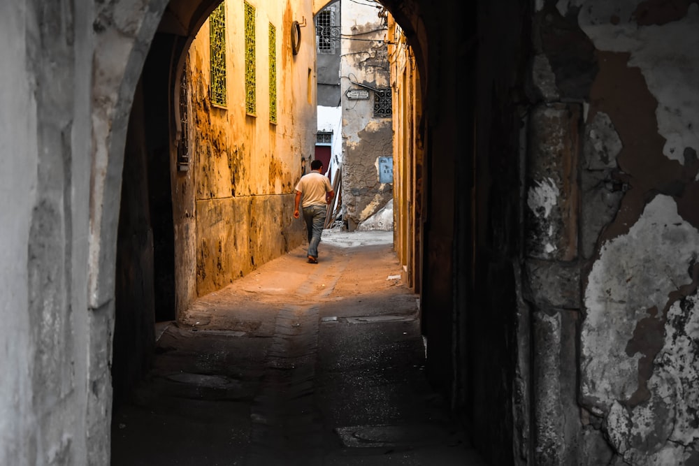 man in white shirt walking on hallway