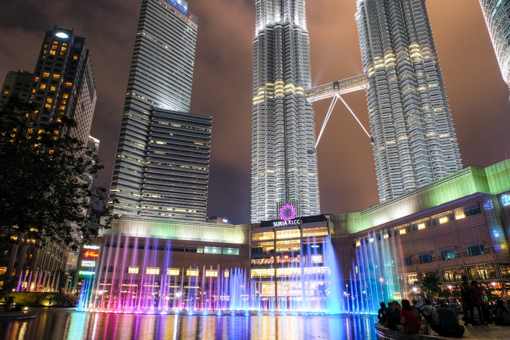 people walking on street near high rise buildings during night time