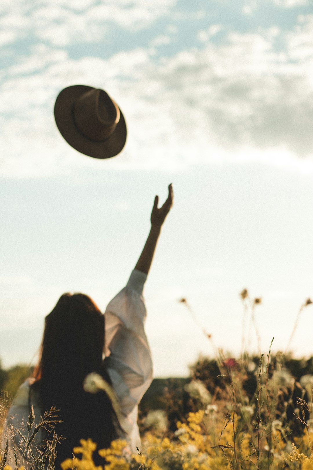 woman in white long sleeve shirt raising her hands