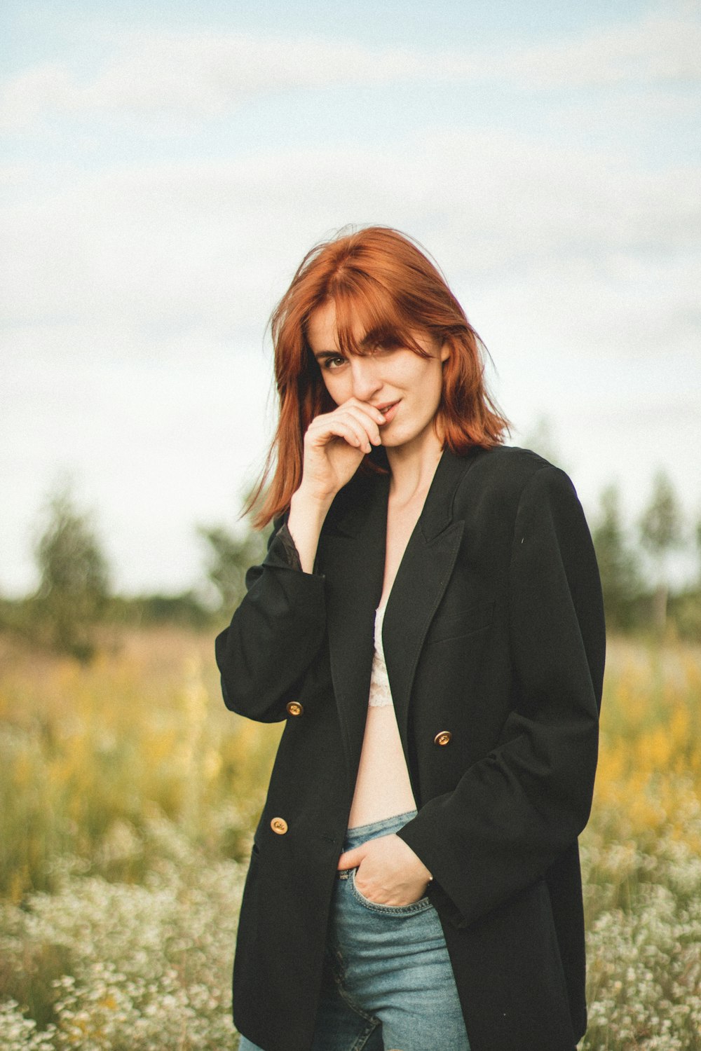 woman in black coat covering her face with her hair