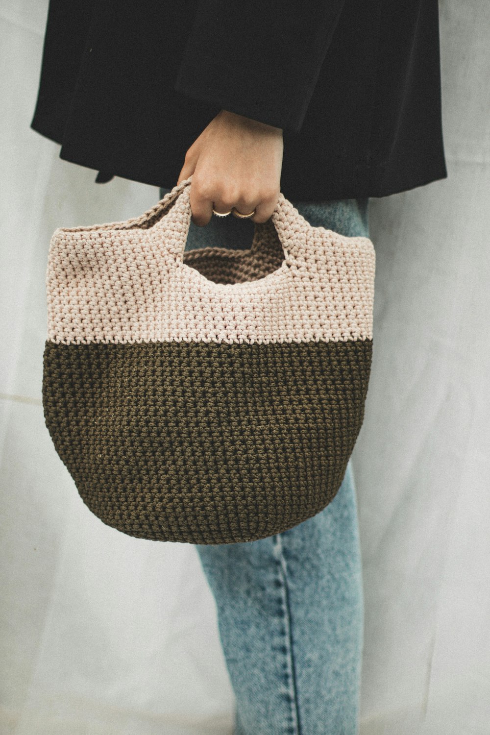 person holding brown and white tote bag