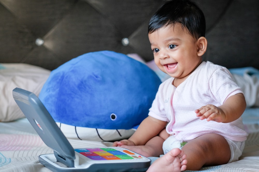 boy in white shirt sitting on blue ball