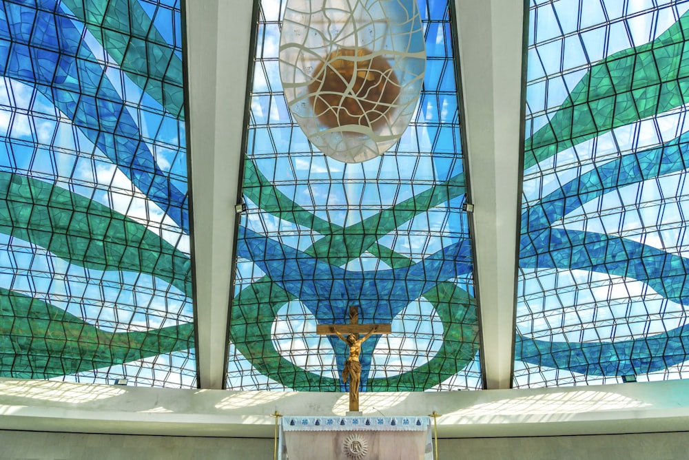 Croix dorée et blanche sur mur de béton blanc