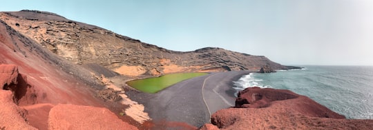 brown mountain near body of water during daytime in Lanzarote Spain