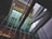 Modern architectural structure featuring geometric lines and a mix of reflective glass surfaces. The building includes vertical and horizontal elements with vibrant green panels contrasting against a predominantly grey and metallic color scheme.