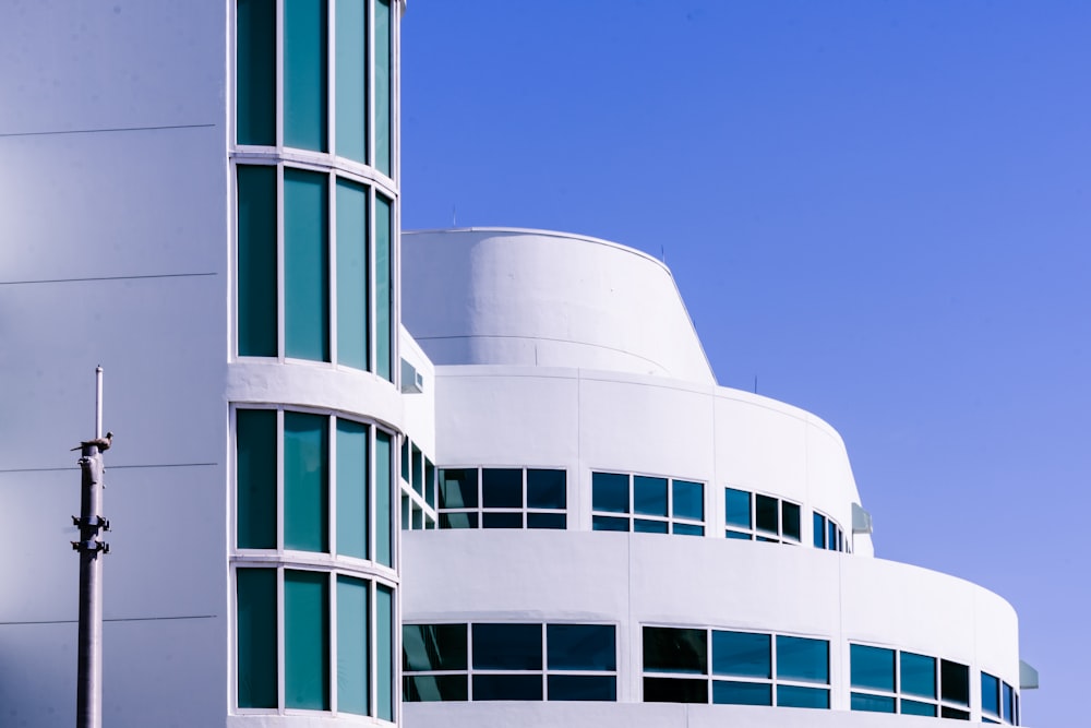 Weißes Betongebäude unter blauem Himmel tagsüber