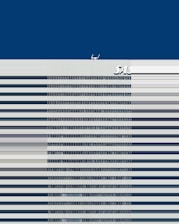 A tall building with horizontal stripes at the front, a deep blue sky in the background, and the letters SAS visible near the top of the building.