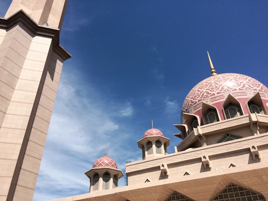 white and brown concrete building under blue sky during daytime in Masjid Putra Malaysia