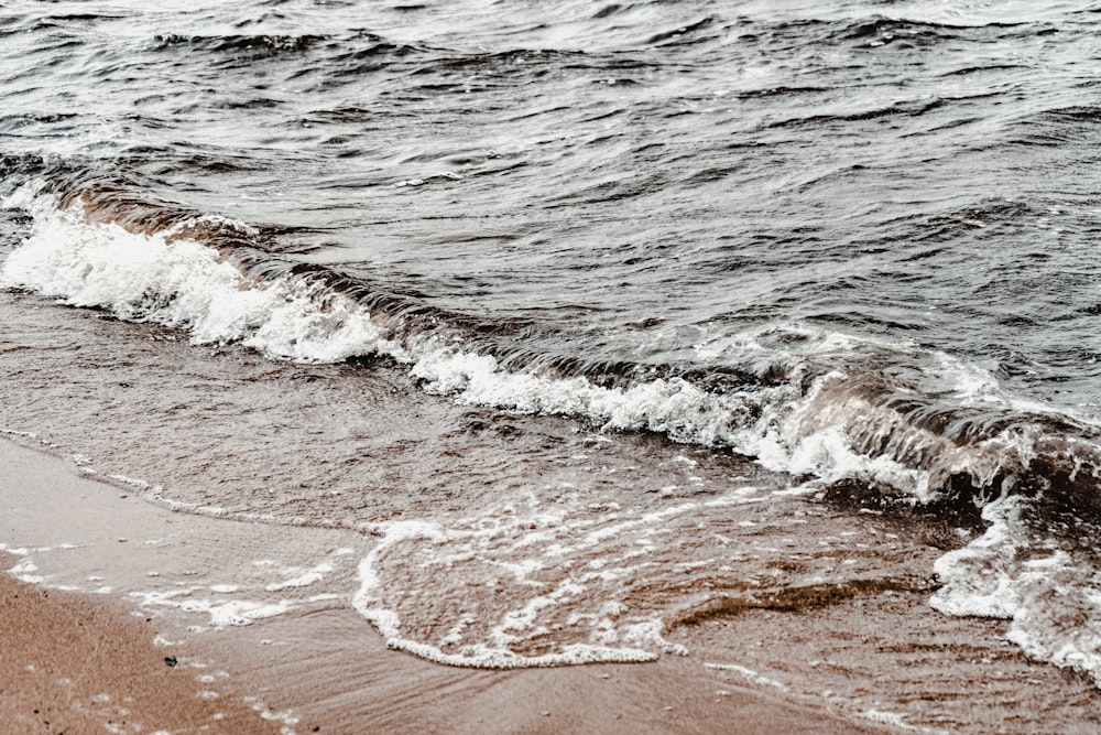 ocean waves crashing on shore during daytime