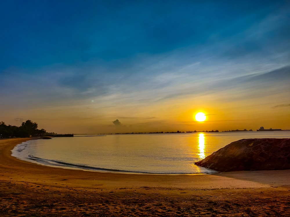 silhouette of island on sea during sunset