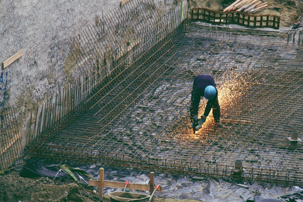 person in black pants walking on brown wooden pathway