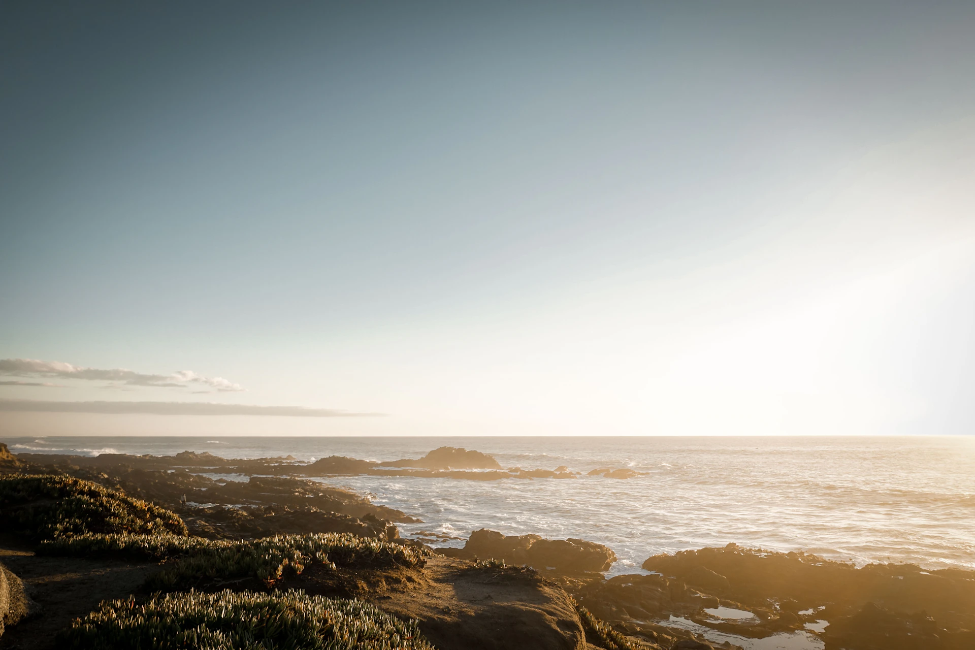 A crisp, high-resolution photo capturing the golden hour light over a serene coastal landscape, emphasizing natural beauty and calm.