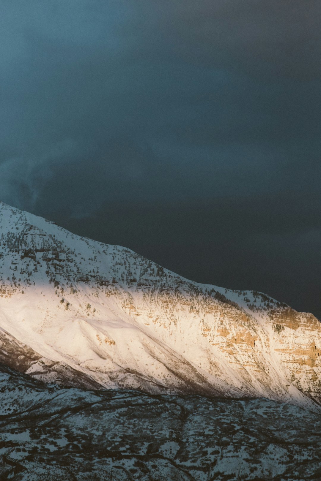 snow covered mountain under gray sky