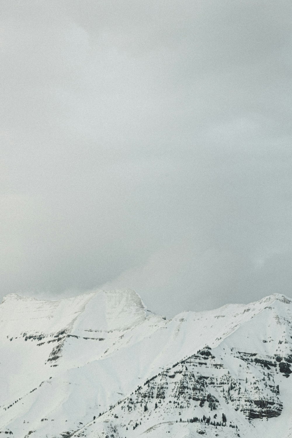 snow covered mountain under gray cloudy sky