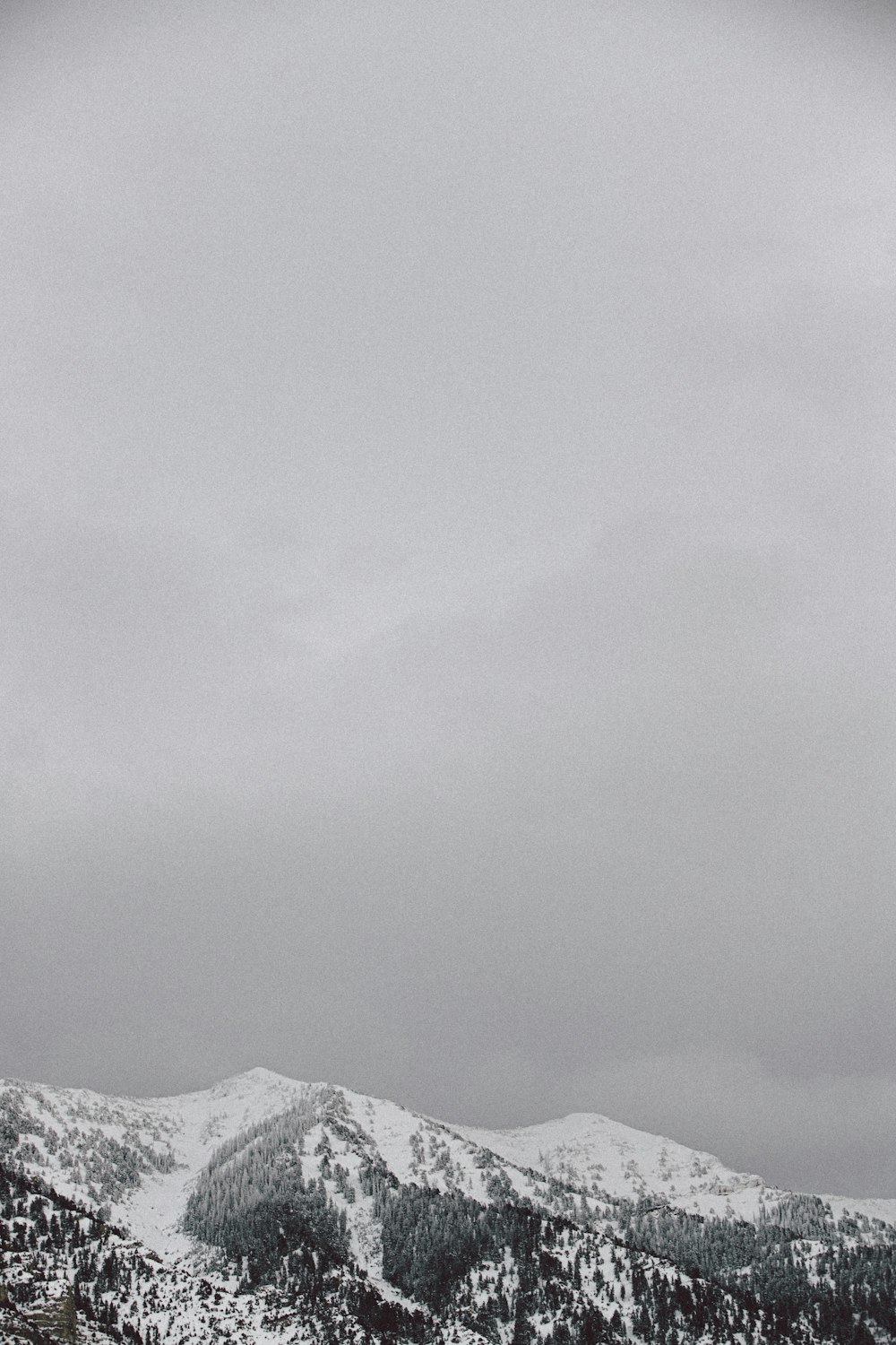 snow covered mountain under cloudy sky during daytime