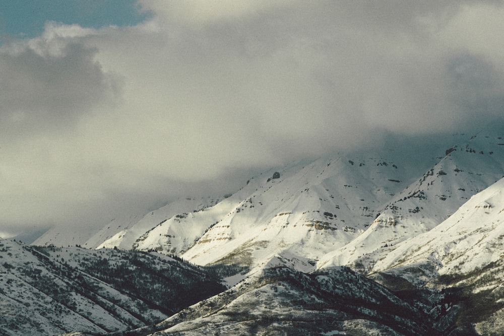 snow covered mountain under cloudy sky during daytime