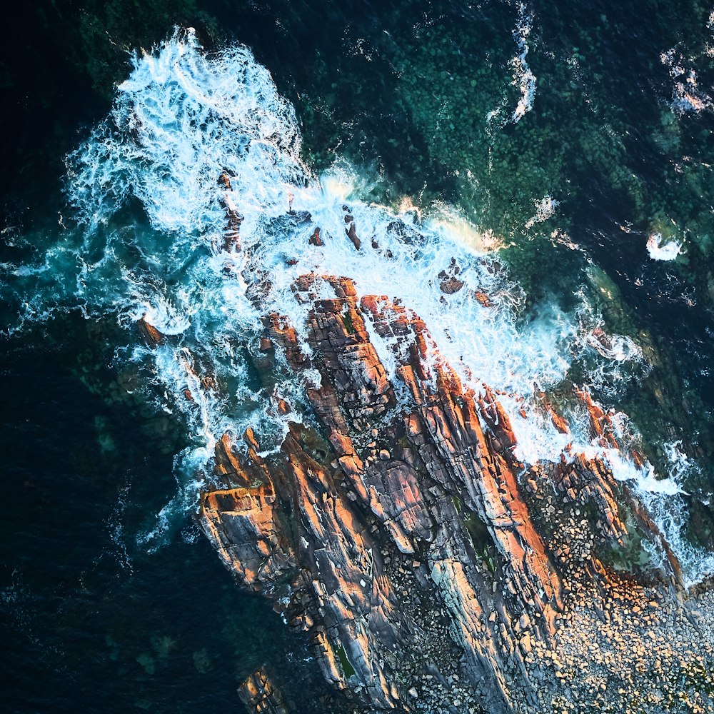 water waves hitting rocks during daytime