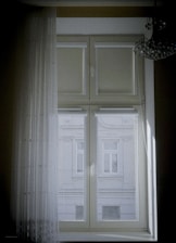 Elegant window dressed with layered curtains and blinds showcasing craftsmanship.