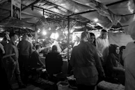 Community gathering at a traditional market with colorful stalls and lively interactions.