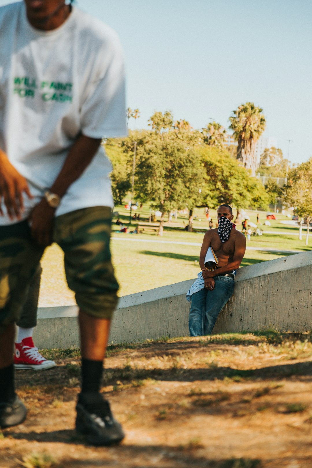 man in white crew neck t-shirt and brown cargo shorts standing beside woman in black