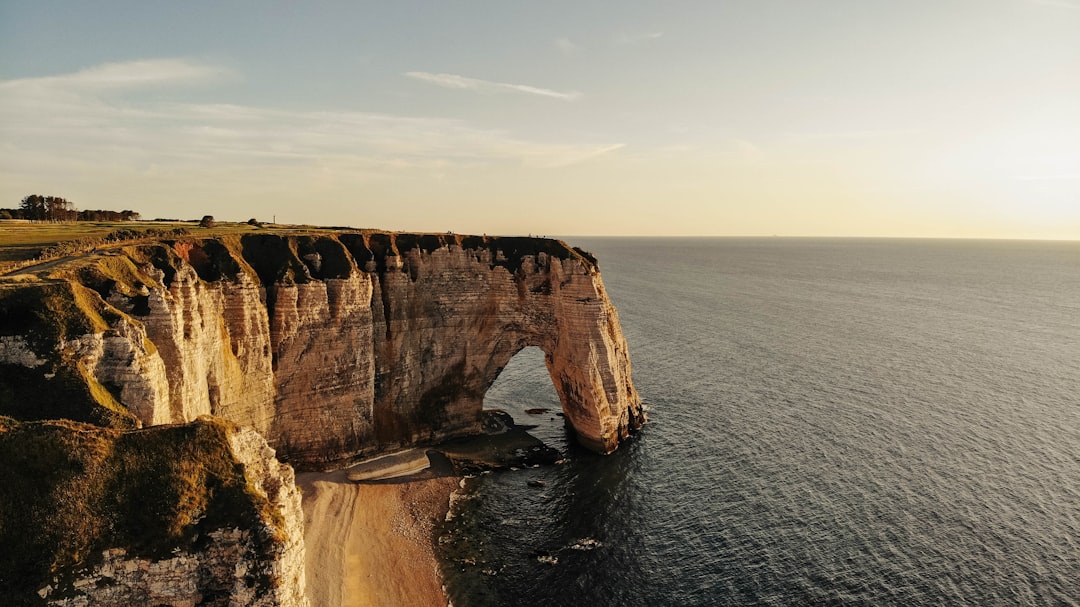 brown rock formation on sea under blue sky during daytime