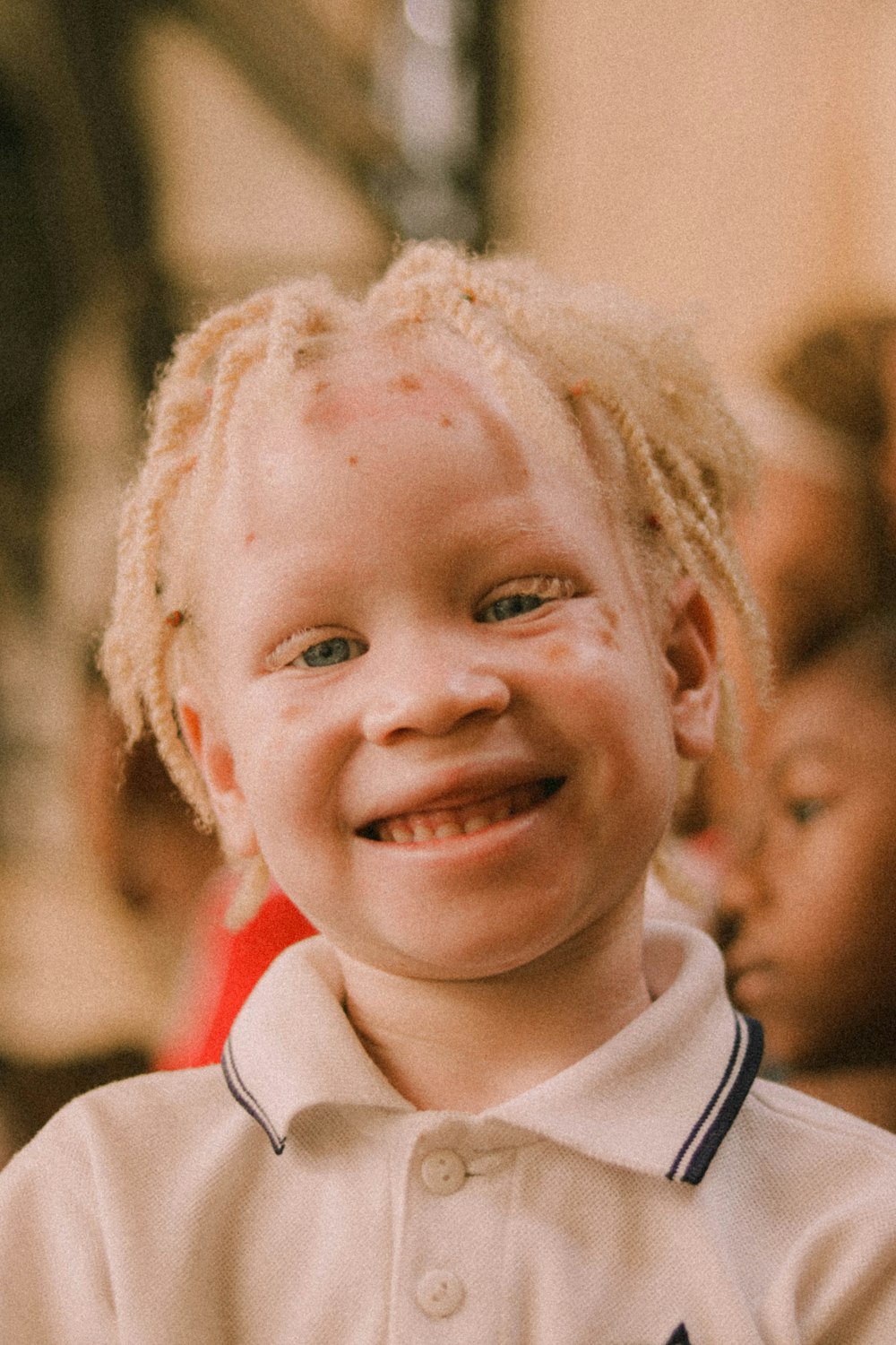 boy in white and red shirt smiling