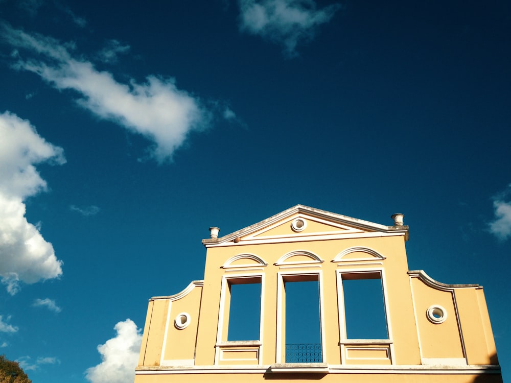 Edificio de hormigón amarillo bajo el cielo azul durante el día
