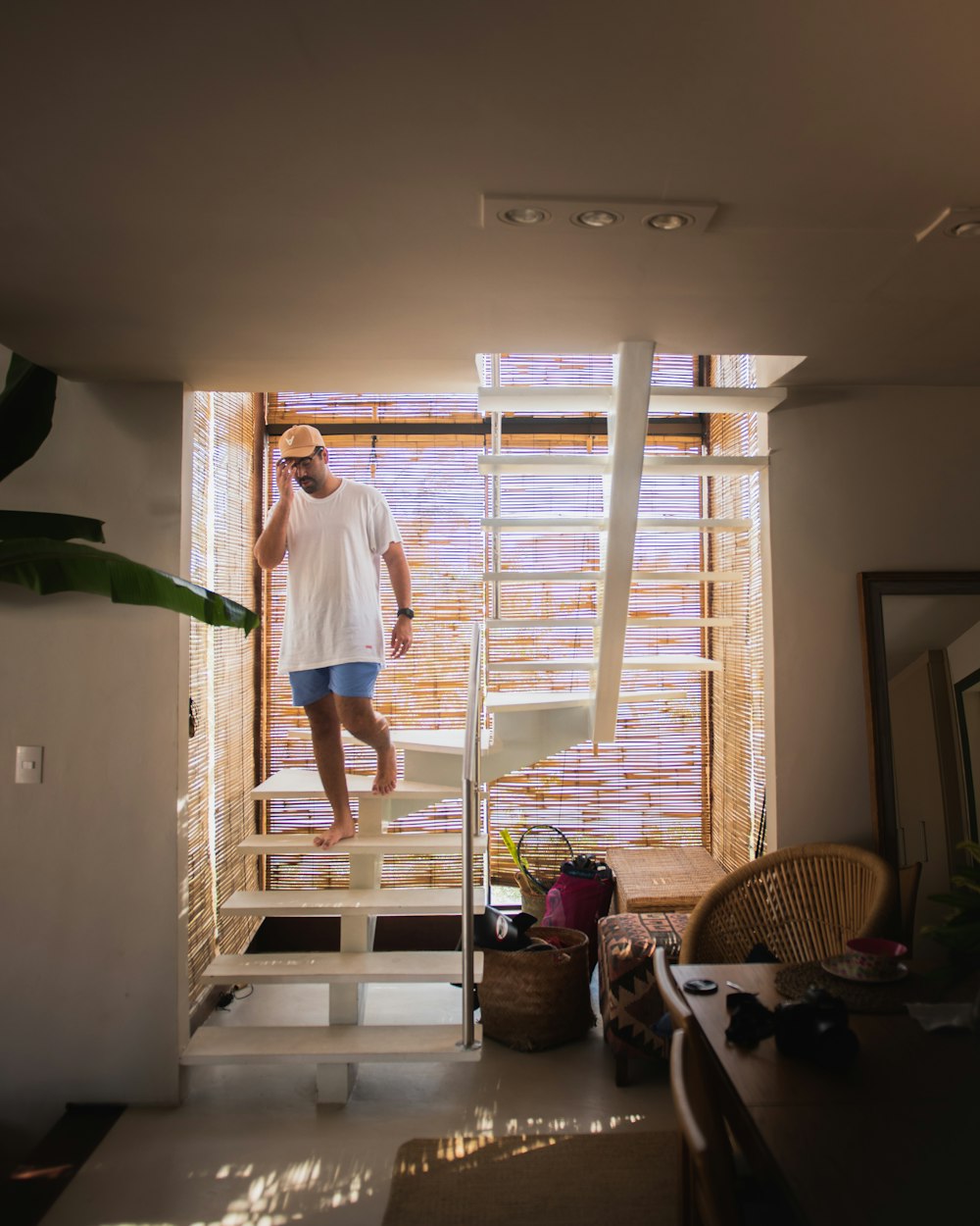 woman in blue shirt and white shorts standing on white wooden staircase