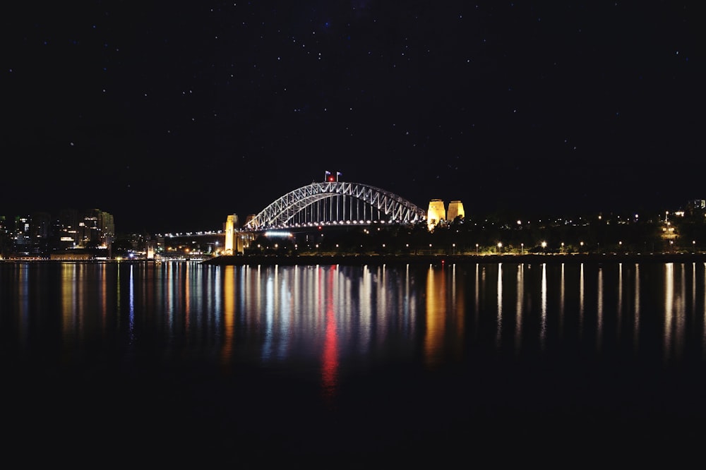 lighted bridge over body of water during night time