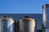 Rows of colorful water tanks displayed outdoors against a clear blue sky