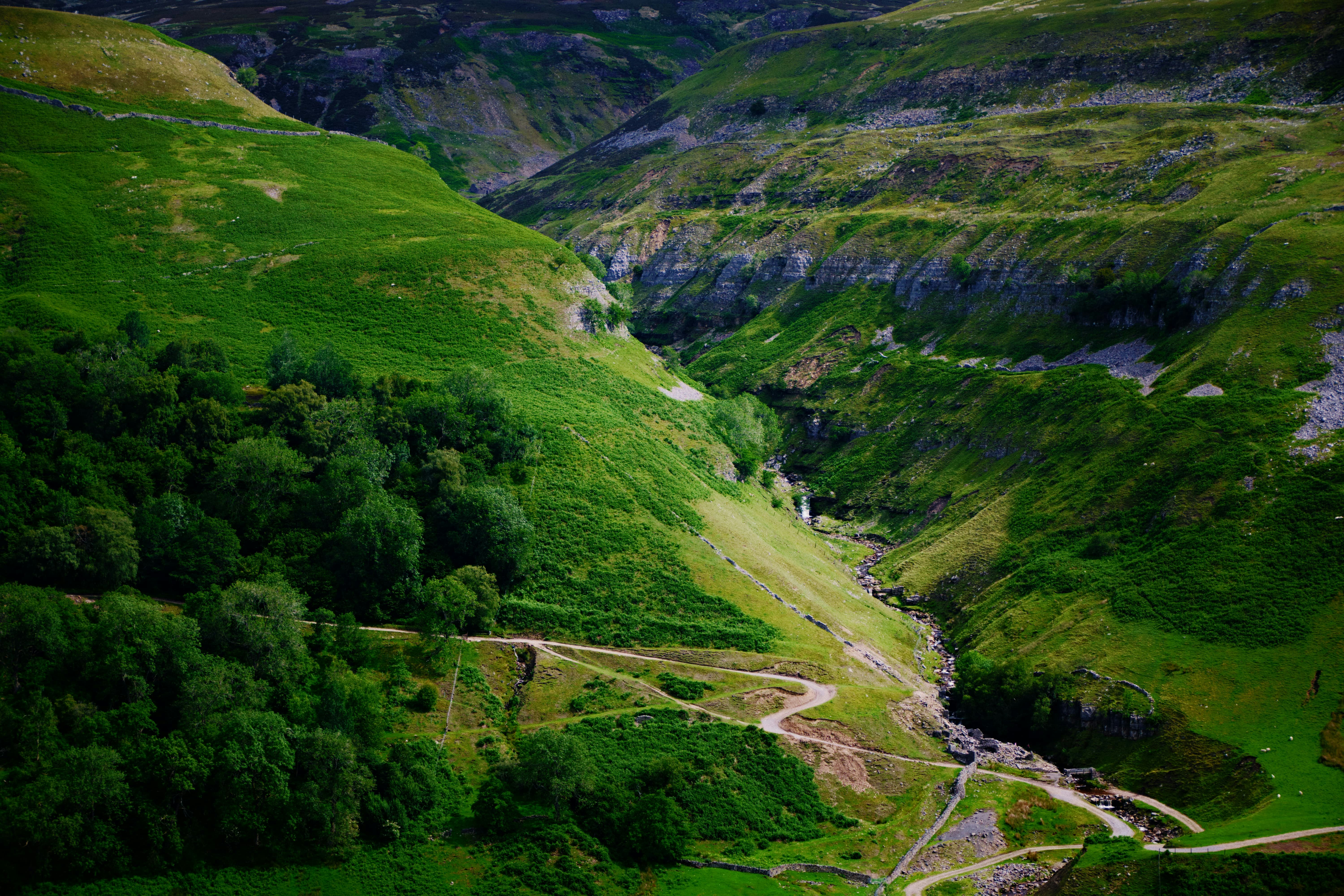 green grass covered mountain during daytime, Zooming in on the deep gash in the land cut by Swinner Gill.