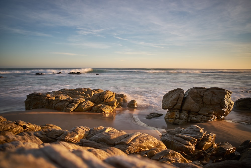 brown rocks on sea shore during daytime