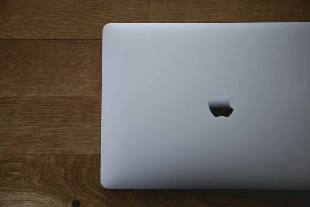 silver macbook on brown wooden table