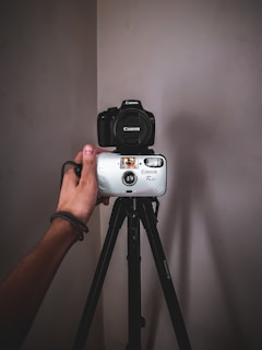 person holding white and black sony camera