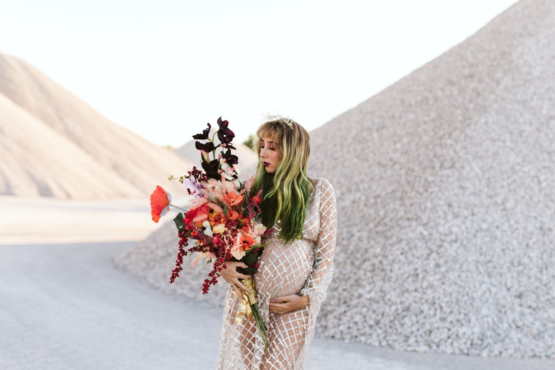 woman in white long sleeve shirt holding bouquet of flowers