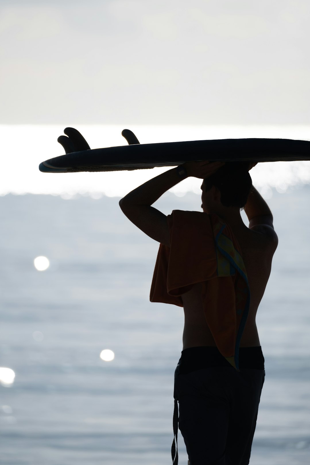 woman in brown and black bikini holding white surfboard