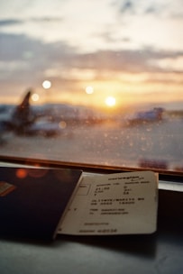 A happy traveler holding a boarding pass with a clear blue sky in the background.