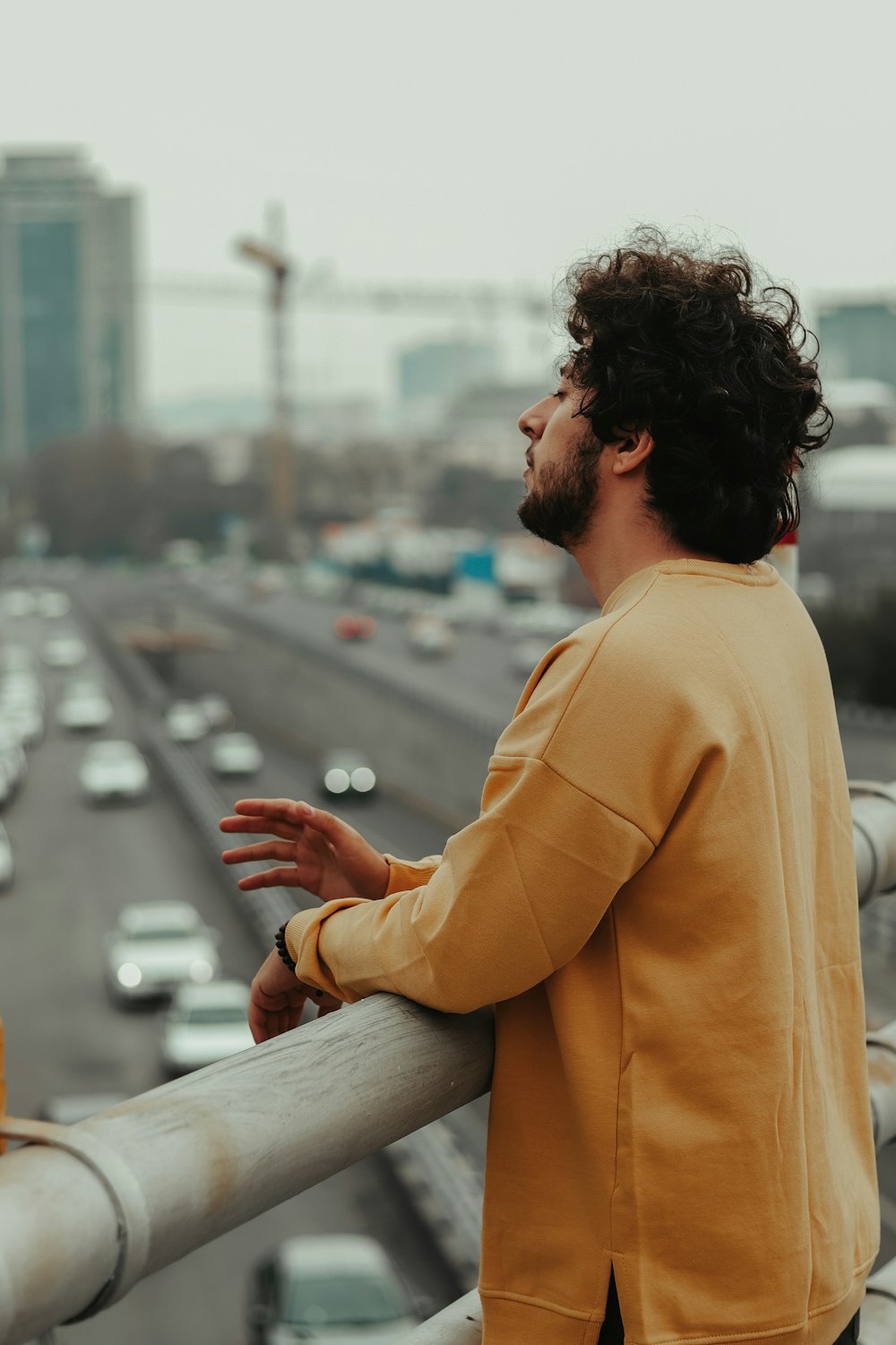 man in yellow dress shirt sitting on gray concrete bench during daytime