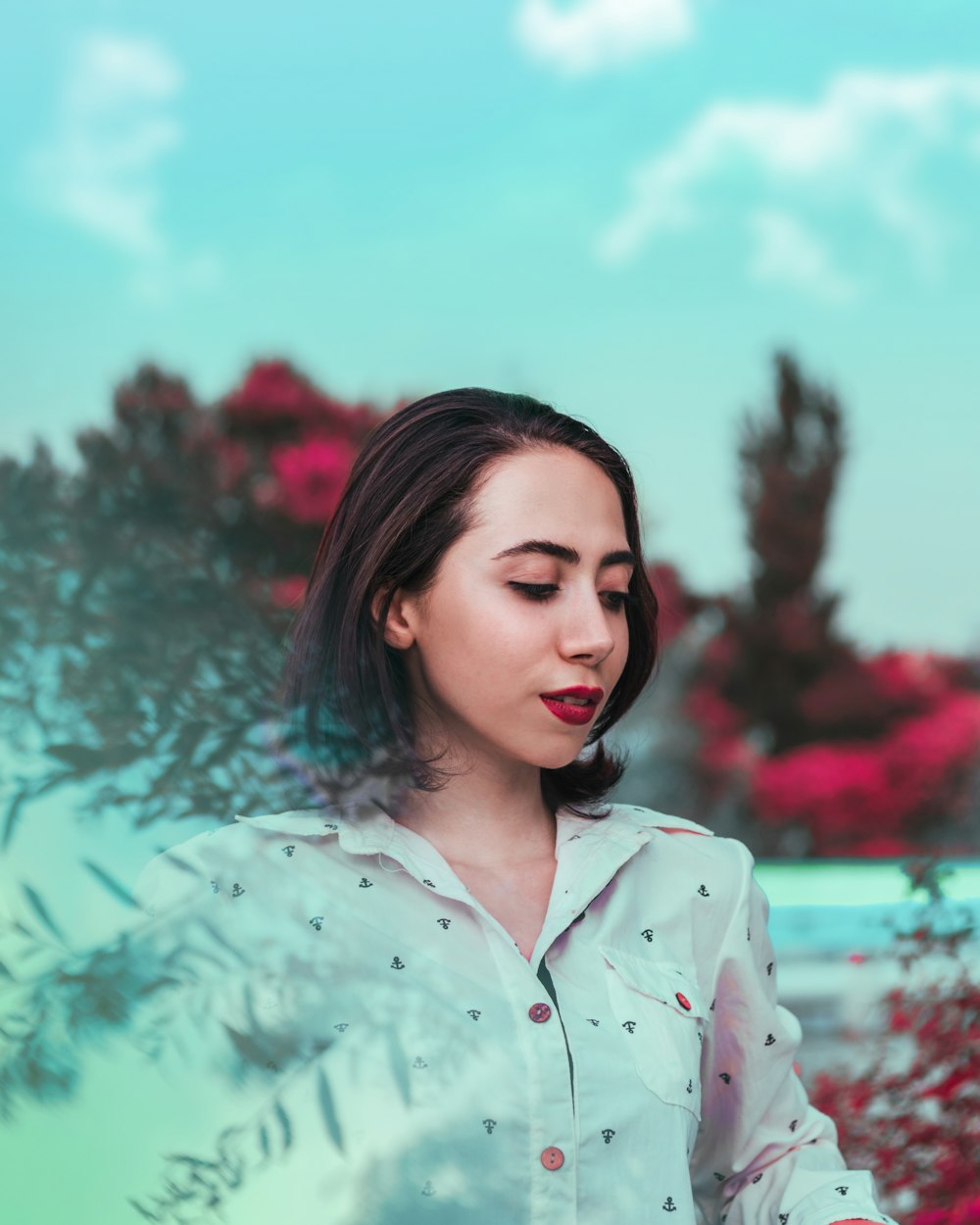 woman in white button up shirt standing near body of water during daytime