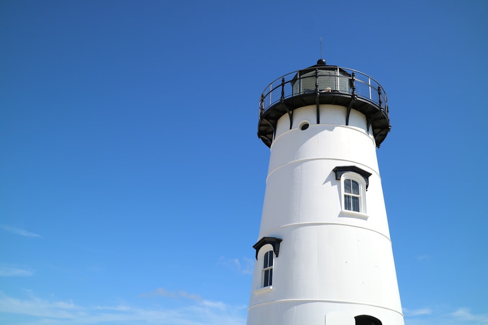 white and black lighthouse under blue sky during daytime