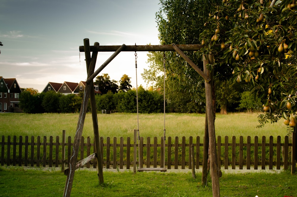 brown wooden swing on green grass field