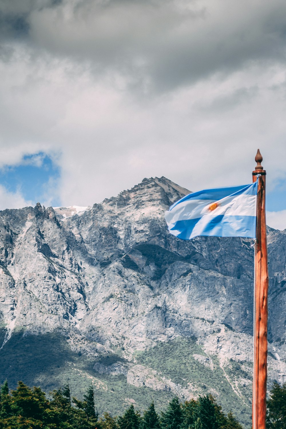 Bandera blanca y azul en mástil de madera marrón