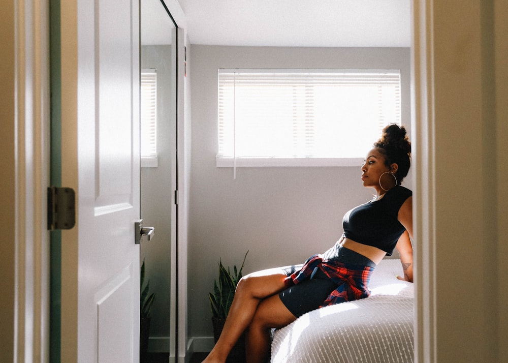 woman in black tank top sitting on white couch