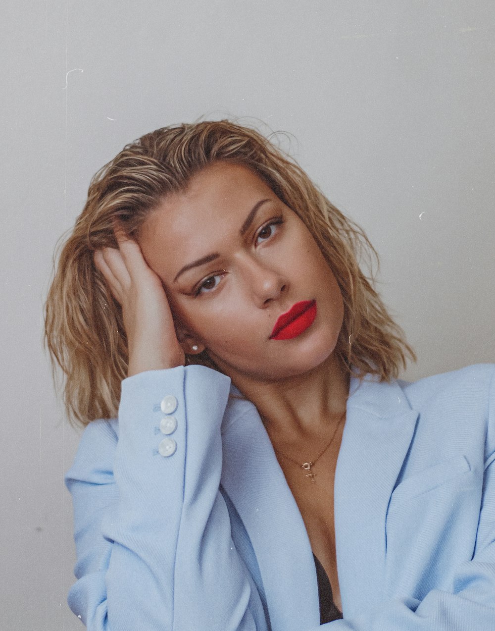 woman in white blazer holding white iphone