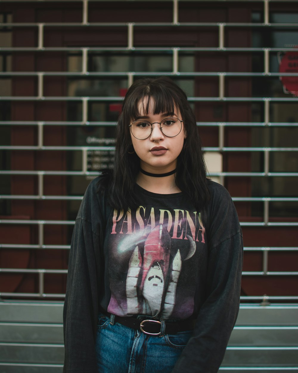 girl in black and pink sweater wearing black framed eyeglasses