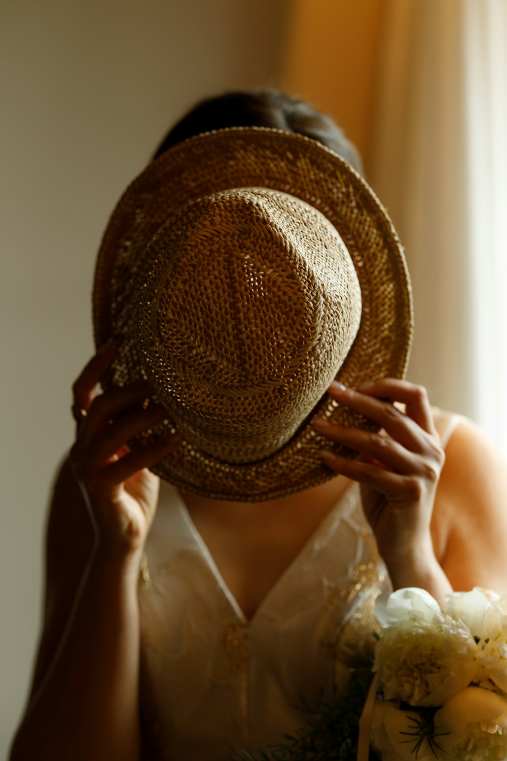 woman in white dress wearing brown sun hat